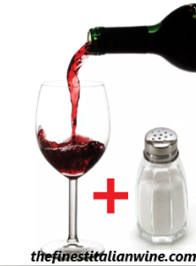 Pouring a bottle of red wine into a glass and salt shaker
