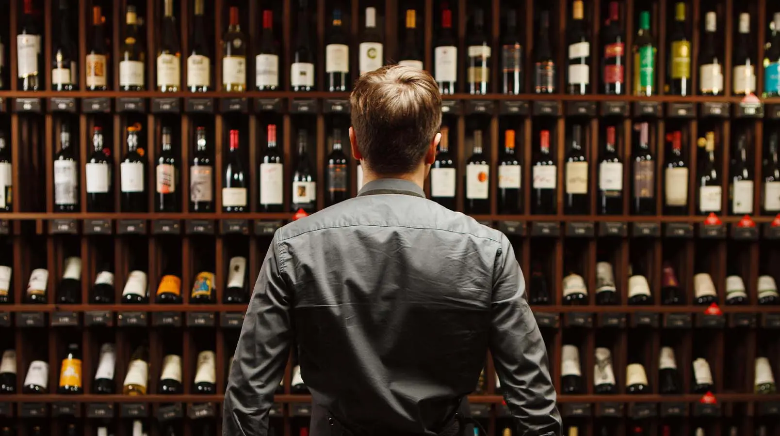 a man standing over bottles of wine